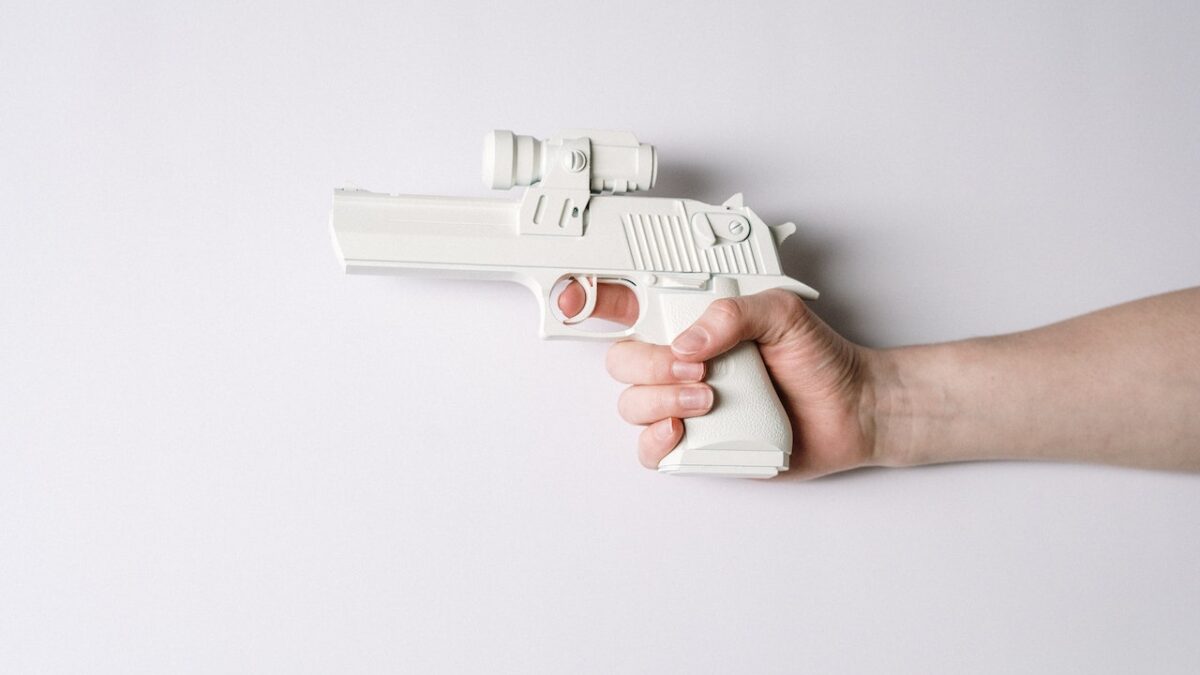 hand holding white pistol