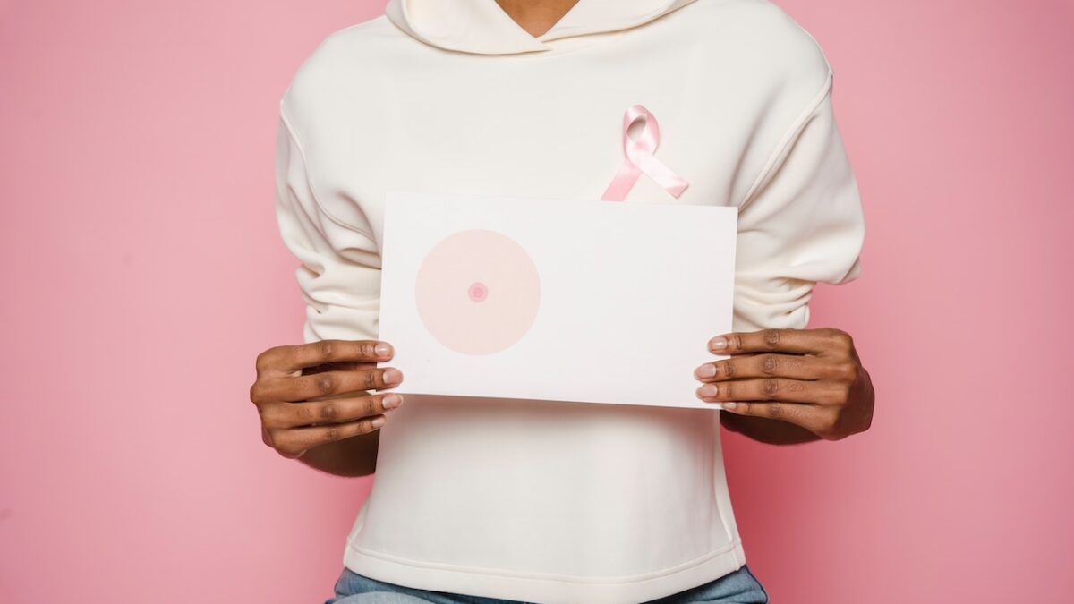 /black-female-holding-paper-with-painted-one-breast-as-symbol-of-cancer