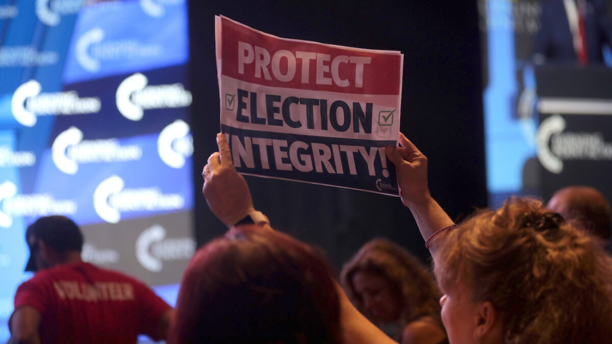 protect election integrity sign being held up at a rally