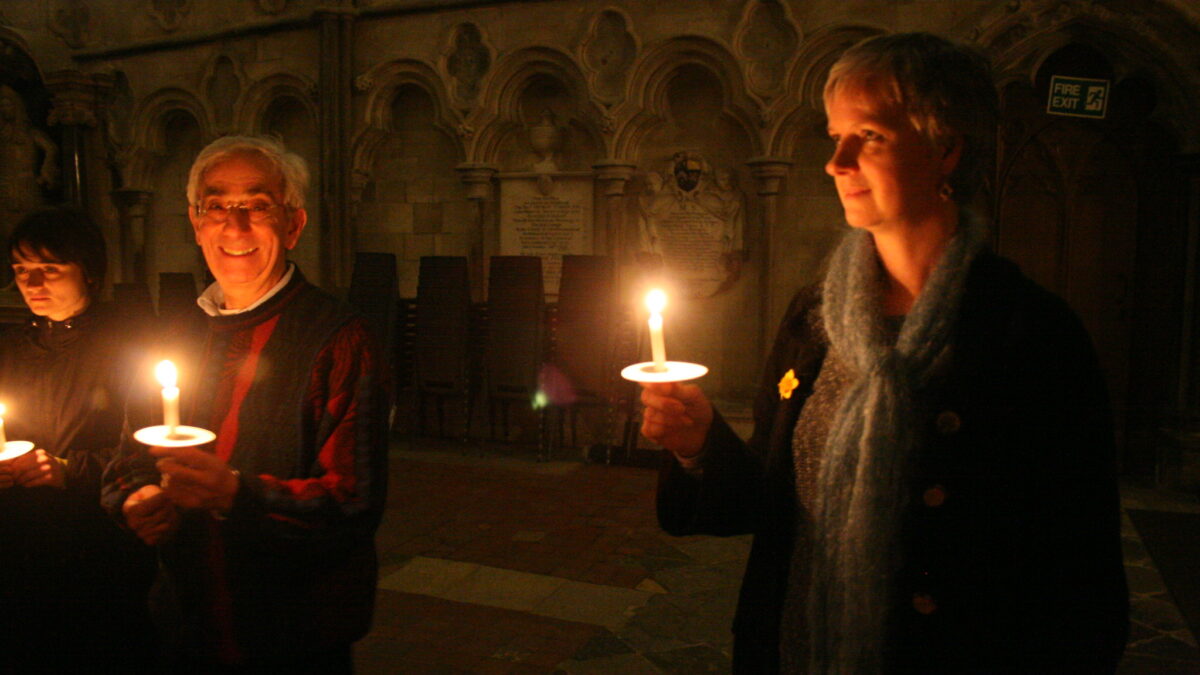 people holding candles singing
