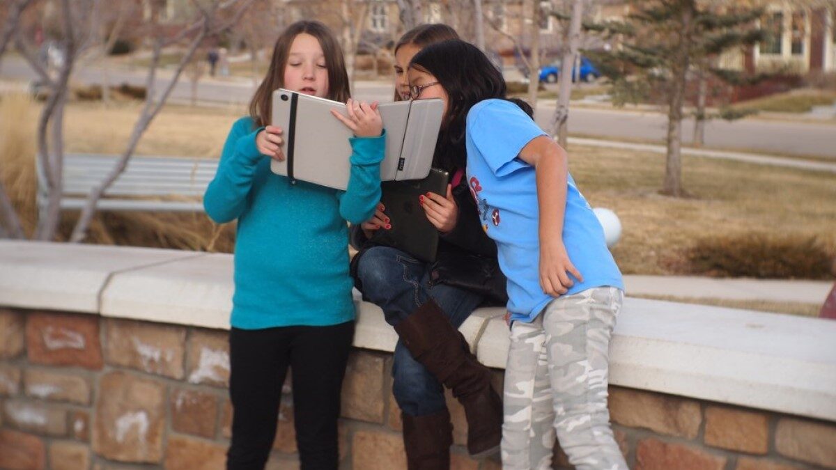 students at school looking at a tablet screen together