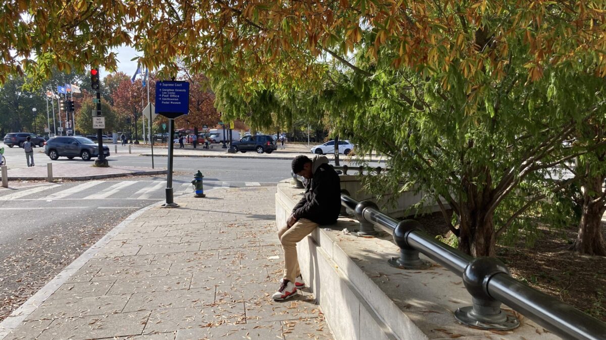 kid sitting with head hung outside DC building