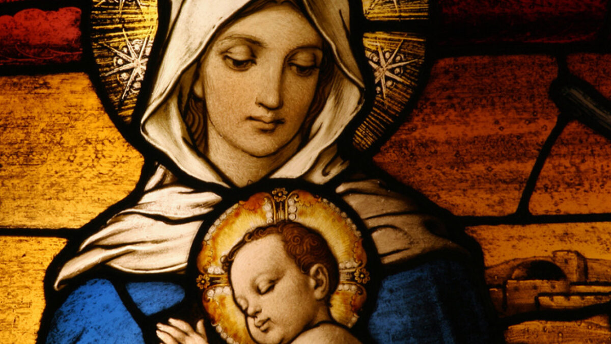 A picture from a Christmas stained glass window shows the Virgin Mary holding baby Jesus.