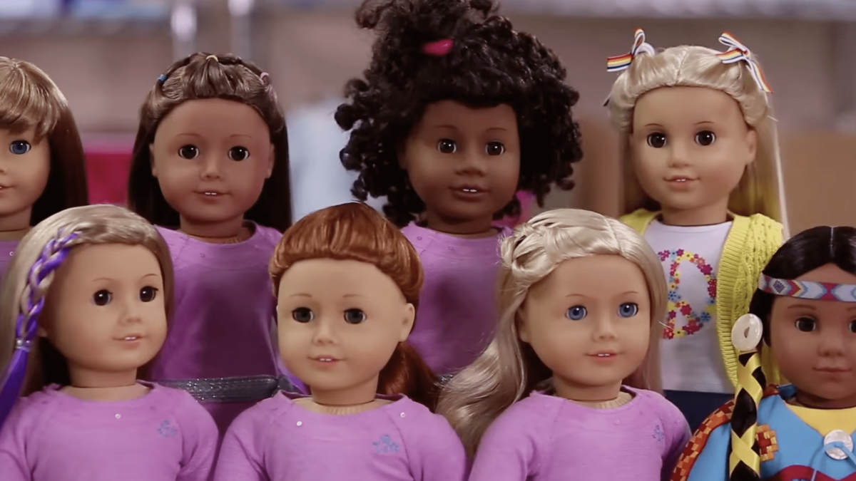 American girl dolls lined up with varying hair and skin colors