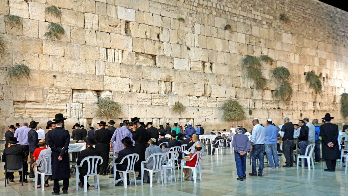 people sitting at tables near the Western wall
