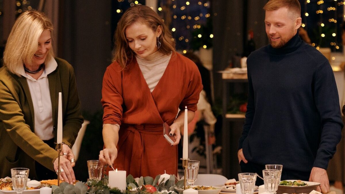 woman lighting candles on Christmas table