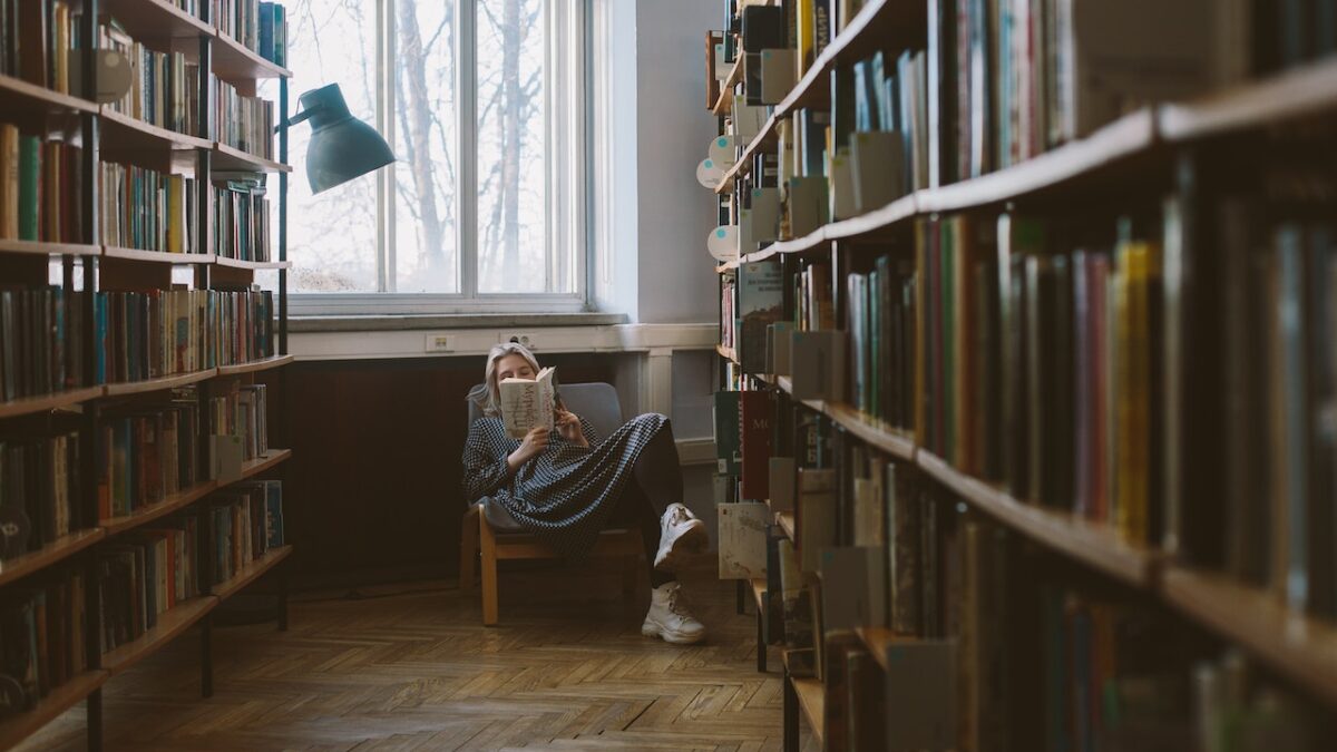 girl reading books in a library