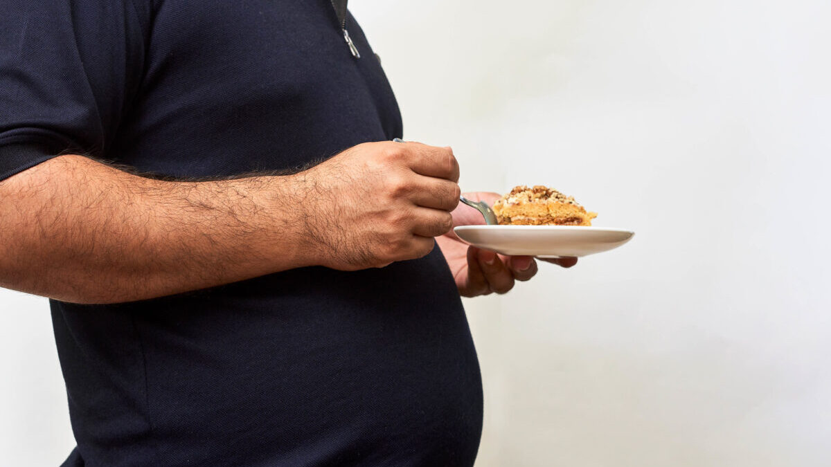 overweight man holding a plate of food