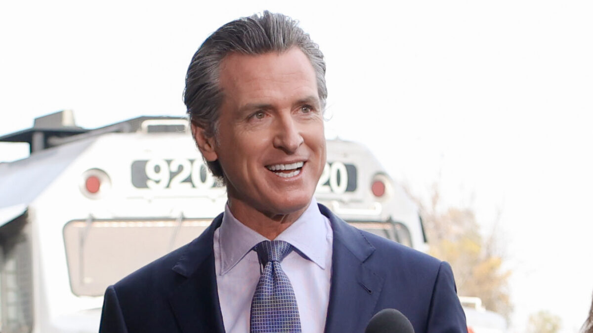 Gavin Newsom talking with train in the background