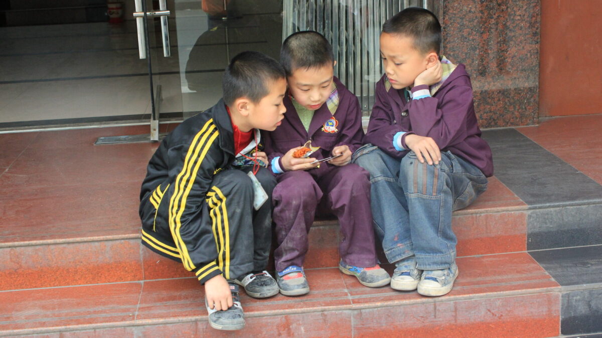 Chinese children sitting together on a step