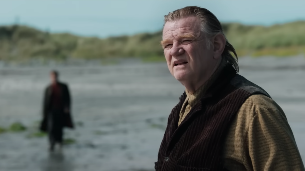 In "Banshees of Inisherin" trailer, an actor furrowing his brow outside against backdrop of Irish Island with another man walking out of focus