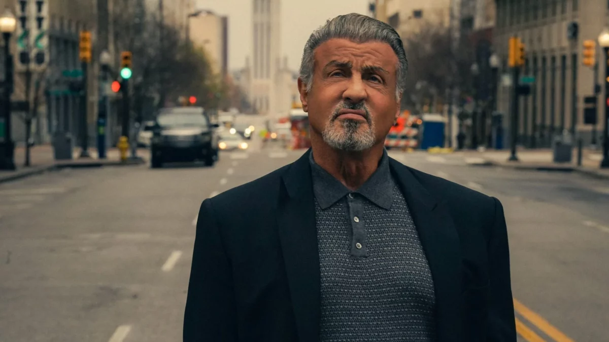 Grey-haired actor playing mob boss standing in middle of street in downtown Tulsa