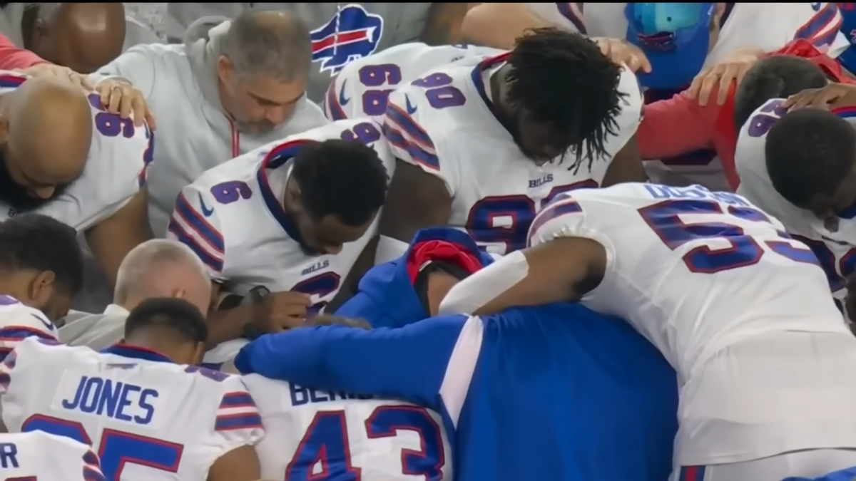 Bills players kneeling in prayer around Damar Hamlin