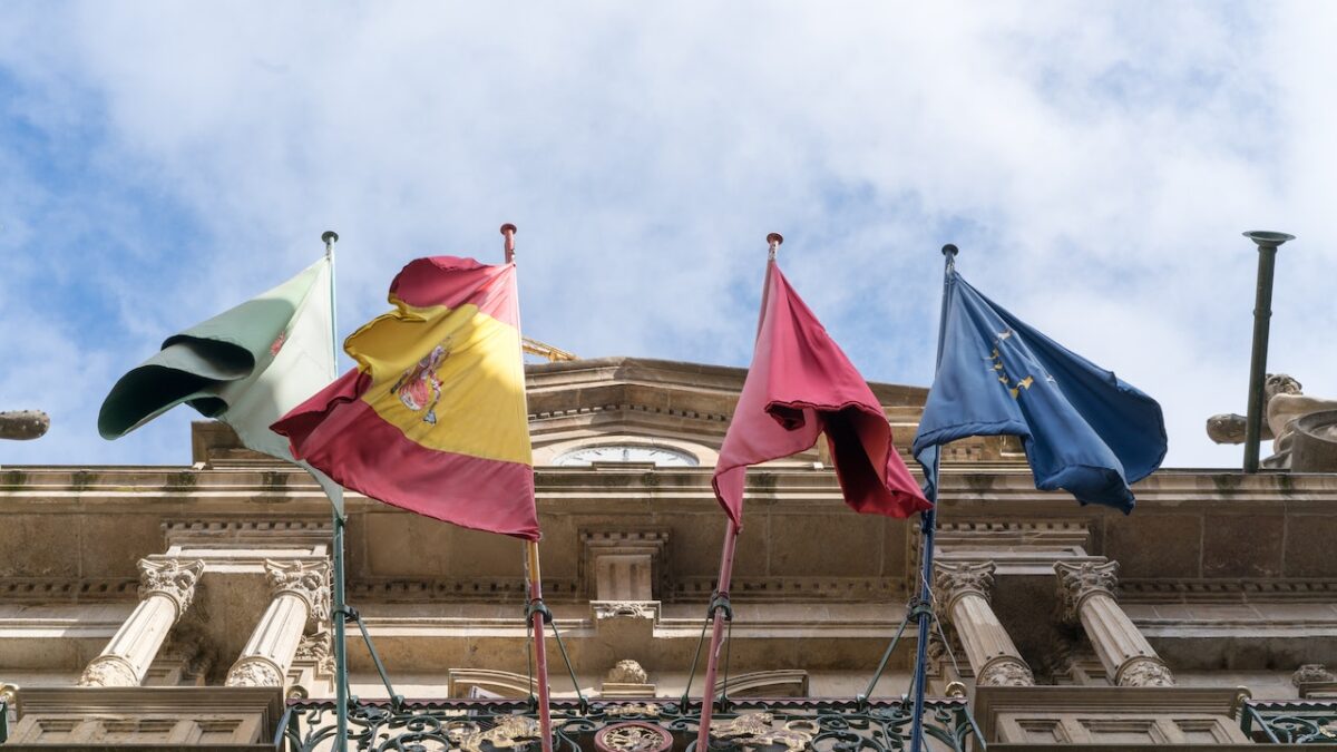 Flags of EU countries hang about ornate building