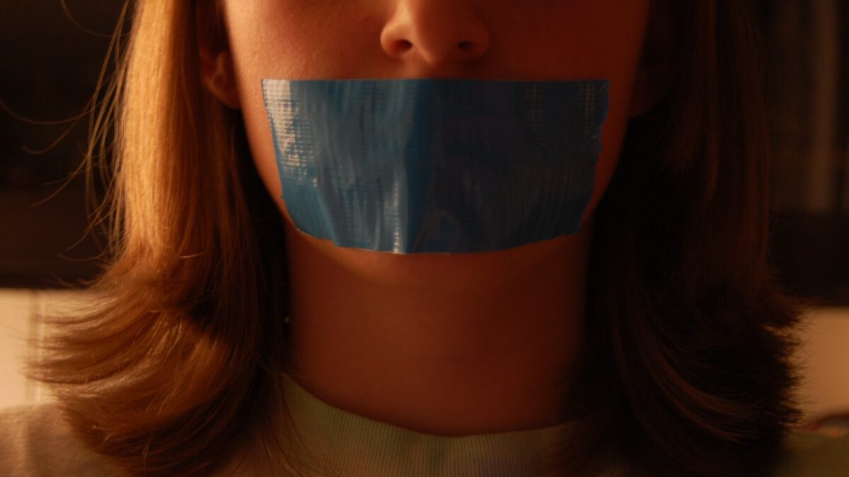 close-up of girl with blue duct tape covering her mouth