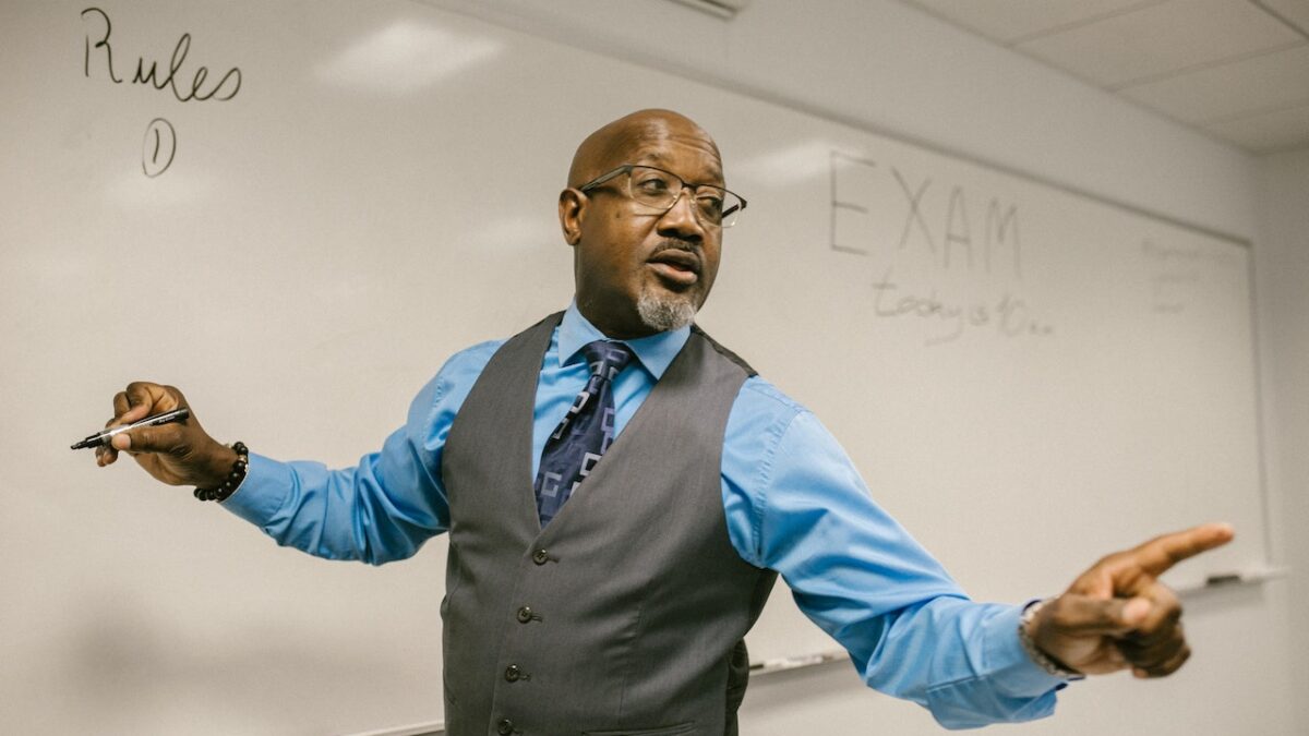 black professor teaching with dry-erase board