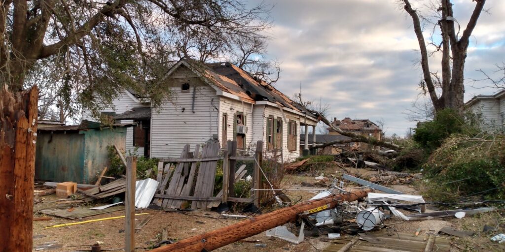 A picture shows homes destroyed by the Selma tornado, with debris strewn across an alley.