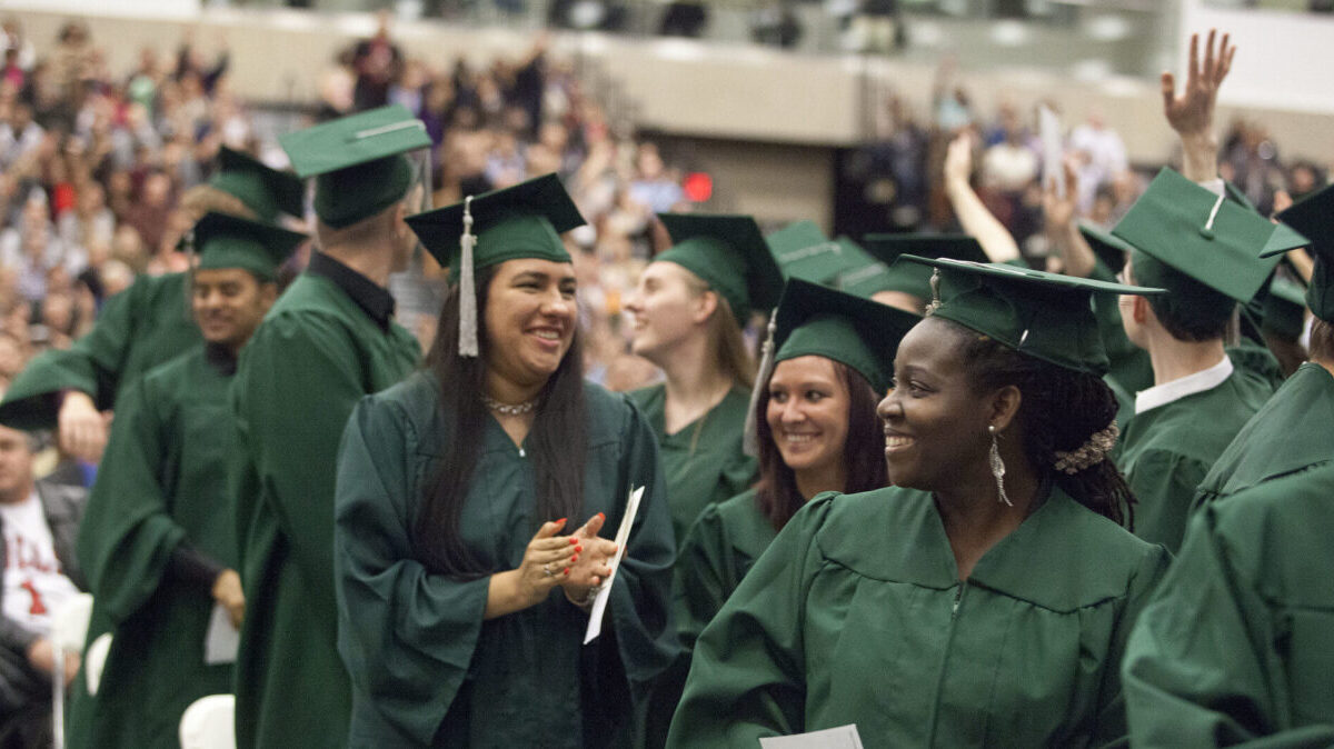 college graduates wearing green caps and gowns