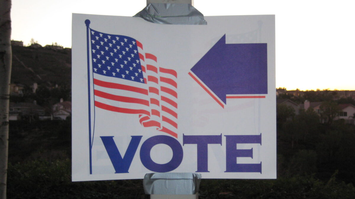 Voting sign with arrow and American flag