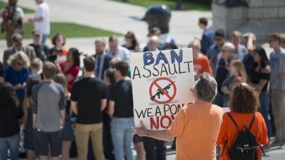 Gun-control advocate carries "ban assault weapons now" poster