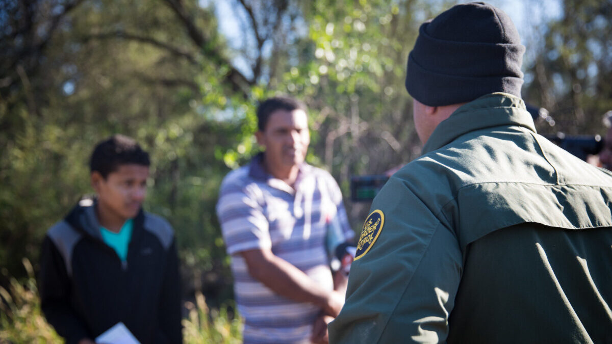 border agent confronts illegal border crossers