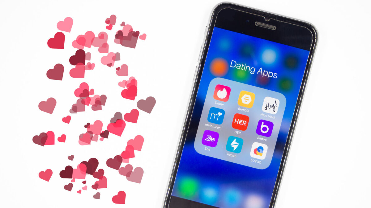 cluster of hearts next to a smart phone with dating app icons on the screen