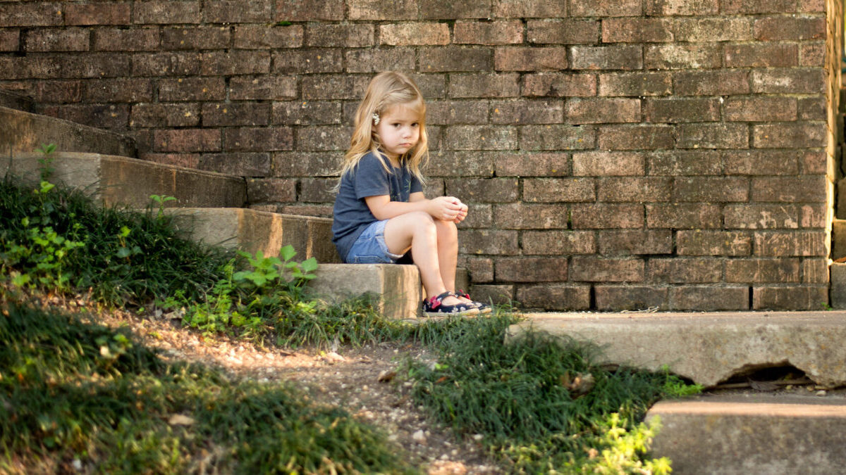 sad child sitting on a step