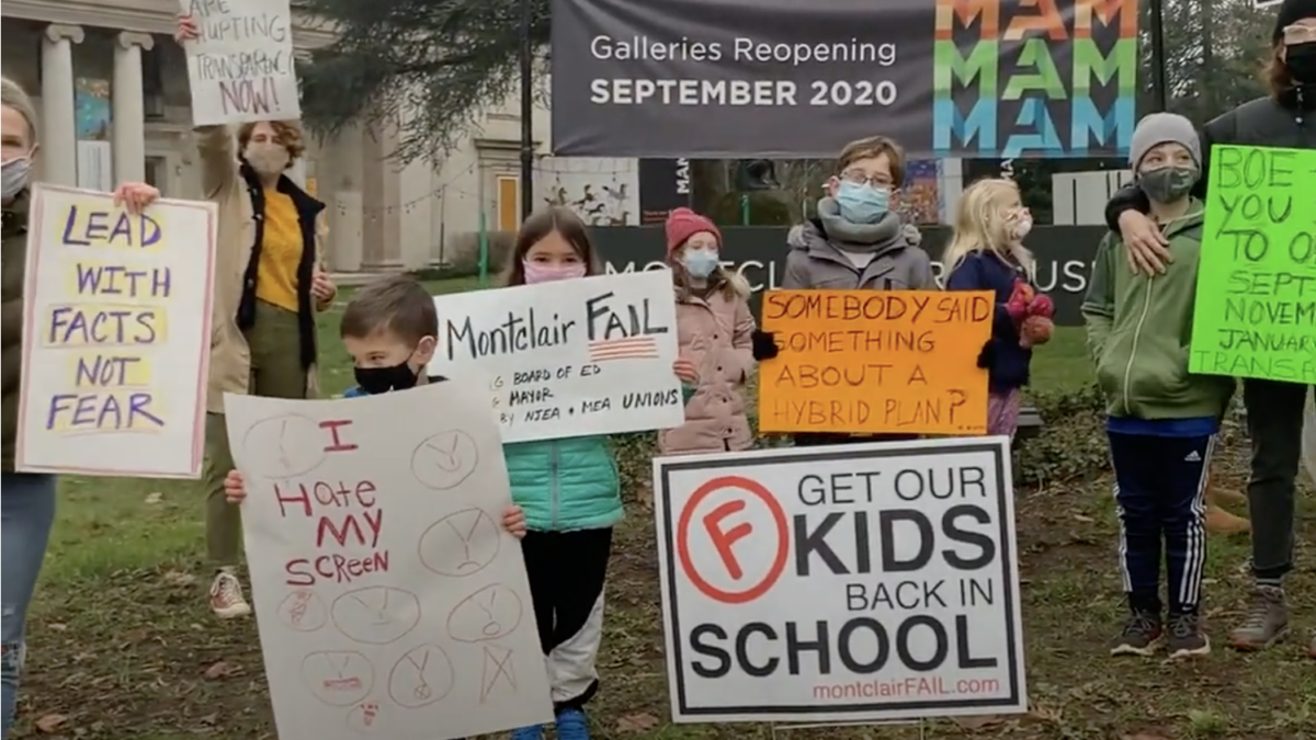 parents and kids protesting school lockdowns with posterboards