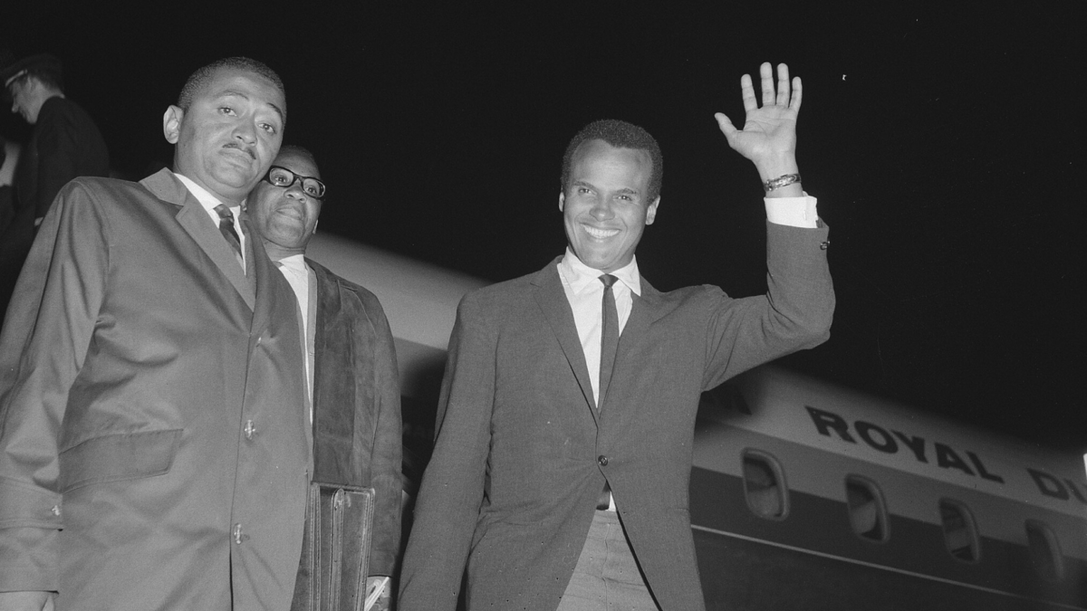 black and white photo of civil rights leaders getting of airplane and waving