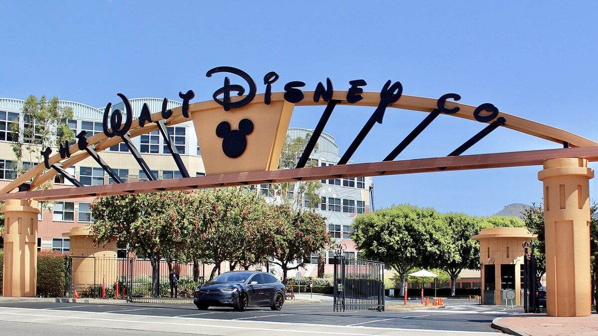 Walt Disney corporate entrance sign with cars driving under it
