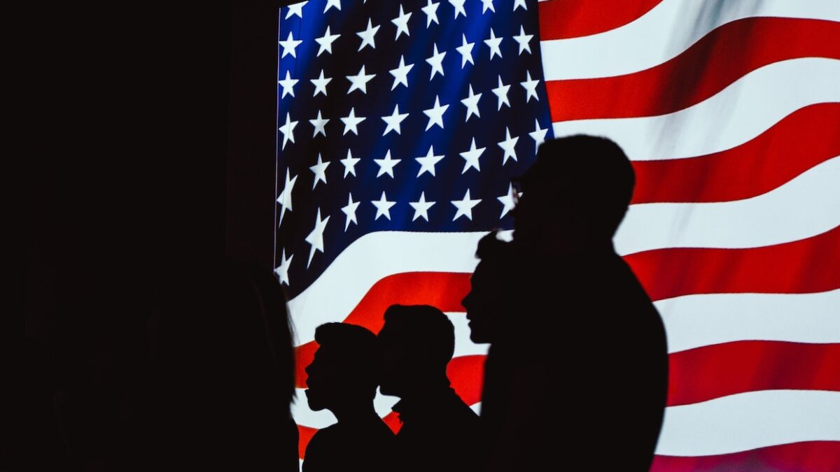 silhouettes against an American flag
