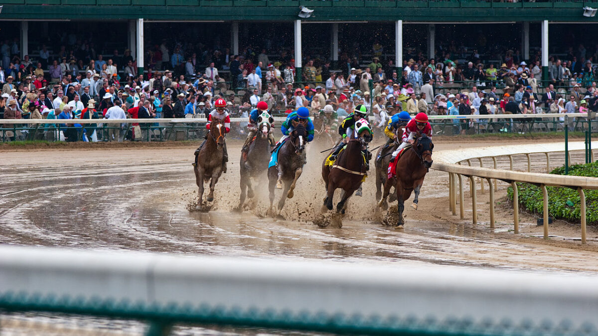 Kentucky Derby Horses Racing around dirt track in front of crowds