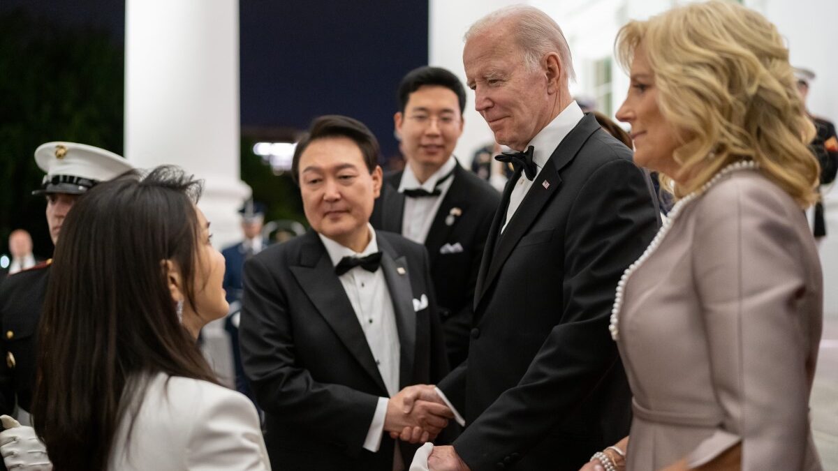 Joe Biden shaking hands and standing with Jill Biden