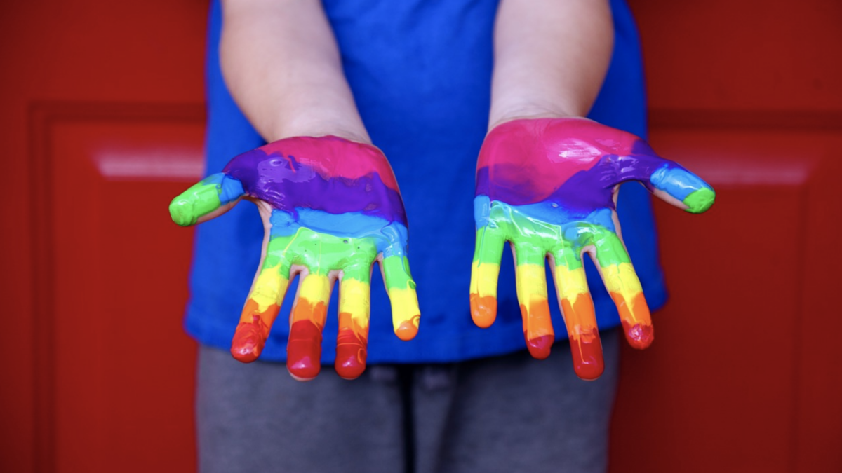 child hands painted rainbow