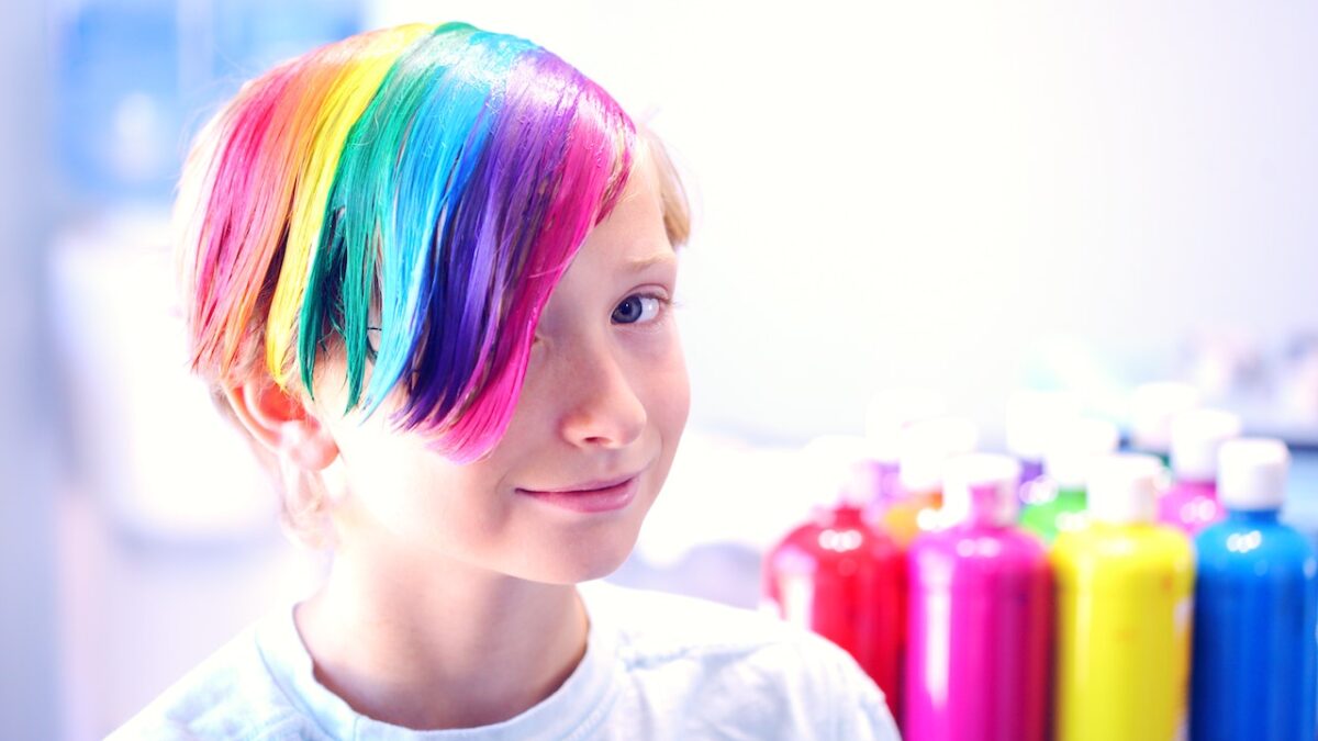 A boy with raindbow hair stares at the camera