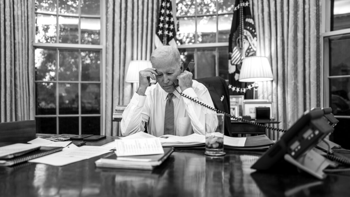 Joe Biden at his desk talking on the phone in black and white