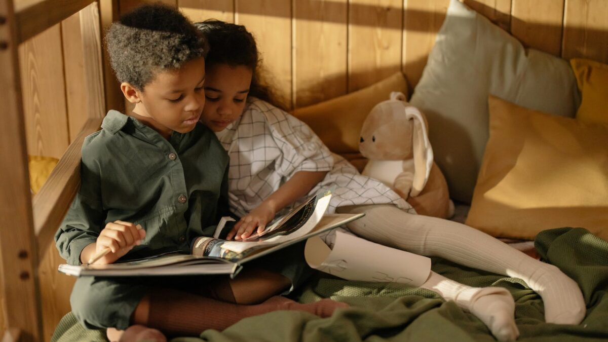 Two children read a book