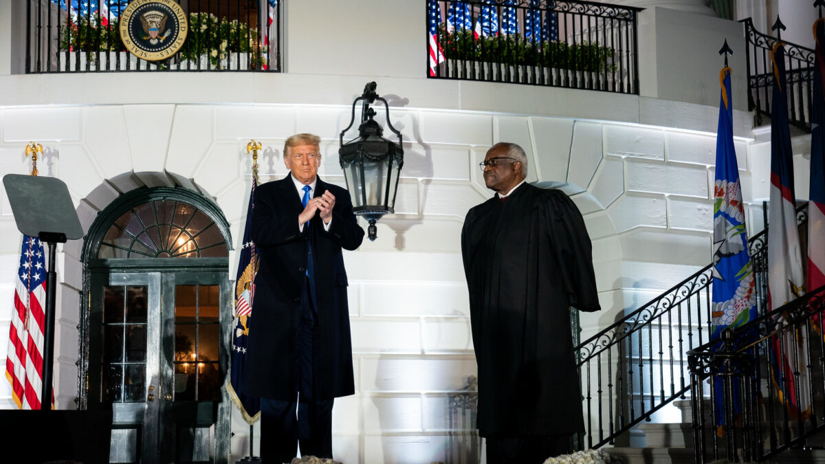 Donald Trump stands next to Justice Clarence Thomas
