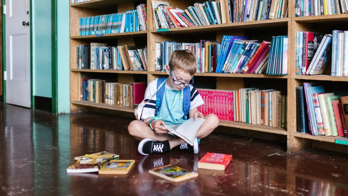 kid reading books in a library