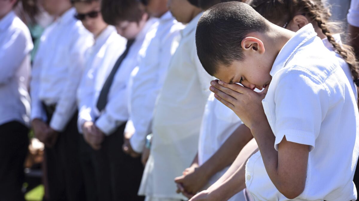 Sixth Grade Choir Singer John Wilson prays during a benediction given at the annual Parade of Wreaths ceremony May 24, 2018 at Joint Base McGuire-Dix-Lakehurst, N.J. The ceremony featured music from the North Hanover Township Schools choir, who sang "God Bless America," the National Anthem and "God Bless the U.S.A." the schools' essay contest winners also read their essays on the true meaning of Memorial Day. (U.S. Air Force photo by Tech. Sgt. Katherine Spessa)