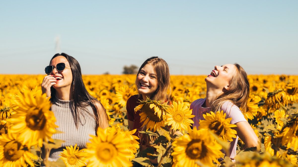 three women in field of sunflowers