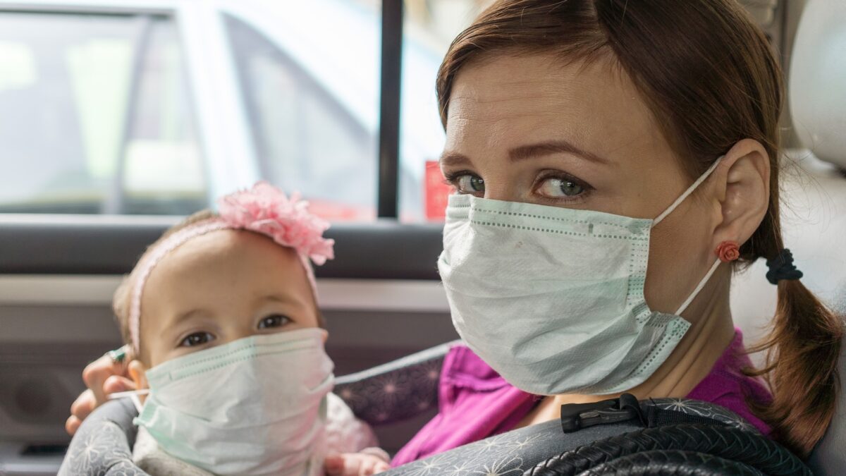 mother and child in car wearing face masks