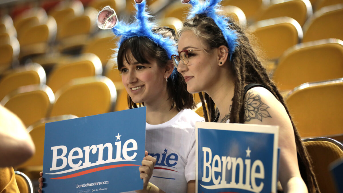 Gen Z Bernie Sanders supporters holding campaign signs