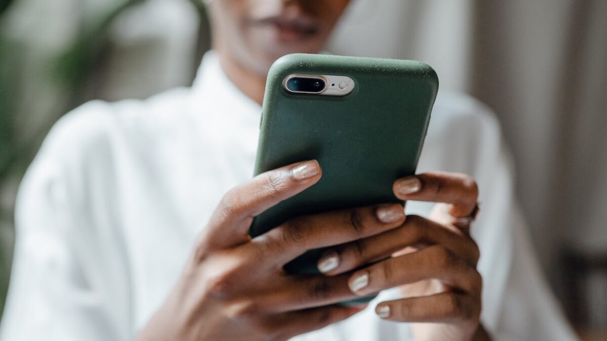close up of black woman holding a green cellphone