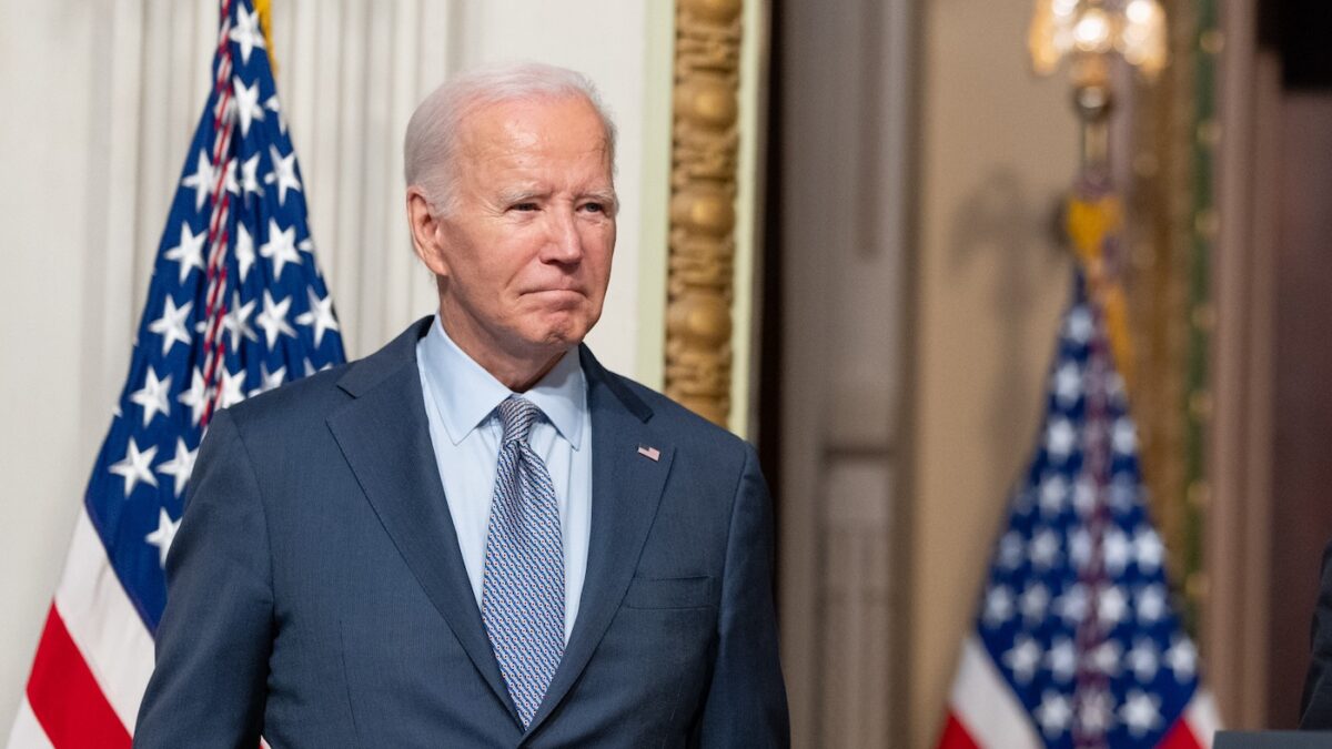 Joe Biden with flags behind him