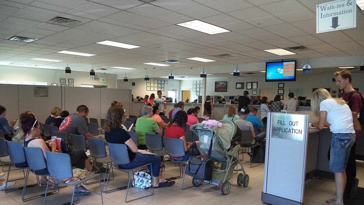 Individuals stand in line at DMV.