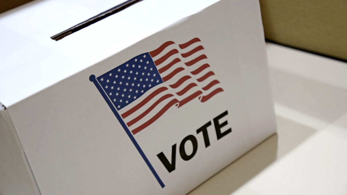 Photo of a white ballot box with an American flag image on it.