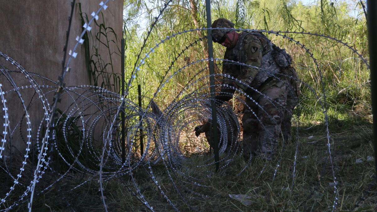 soldier puts up wire along border in Texas