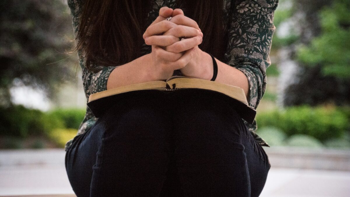 woman praying with Bible