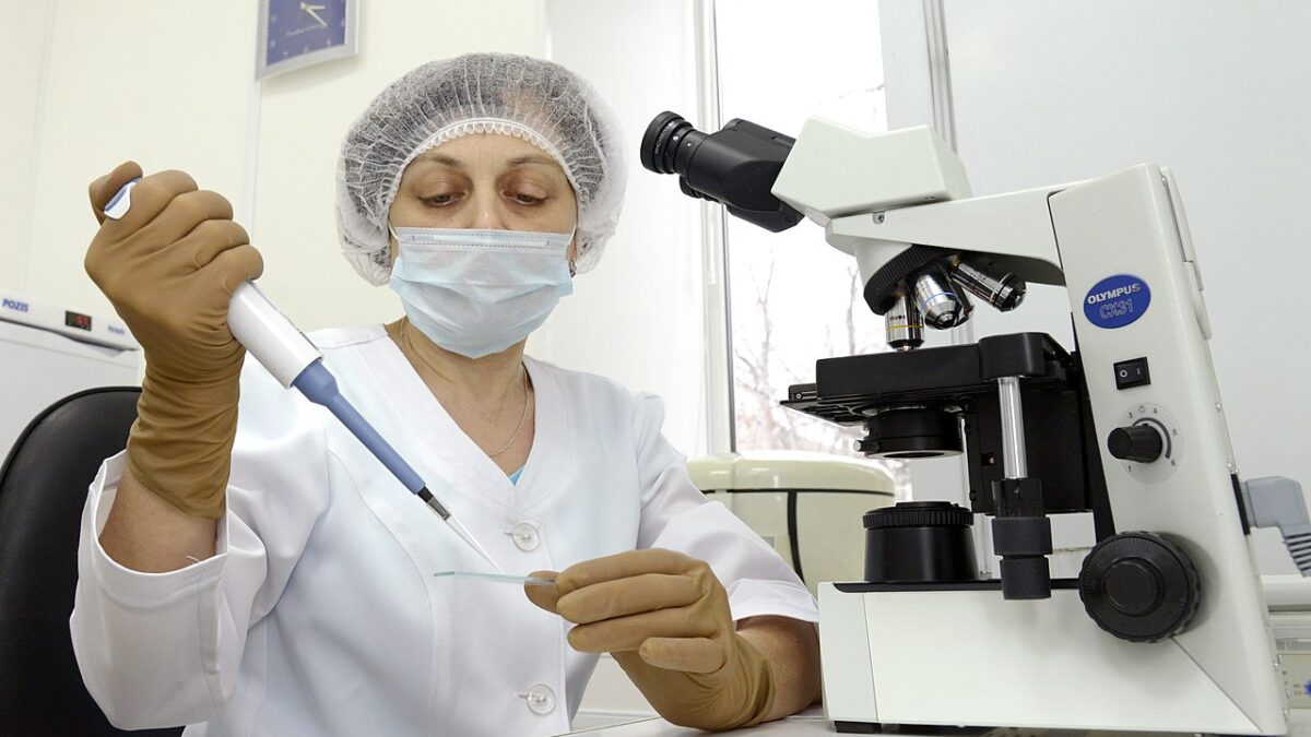 Tech working in IVF lab with microscope